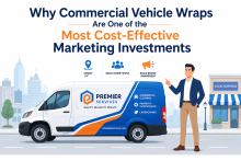 Commercial vehicle wrap displaying company branding and contact information while driving through an urban business district, showcasing mobile advertising and brand visibility.