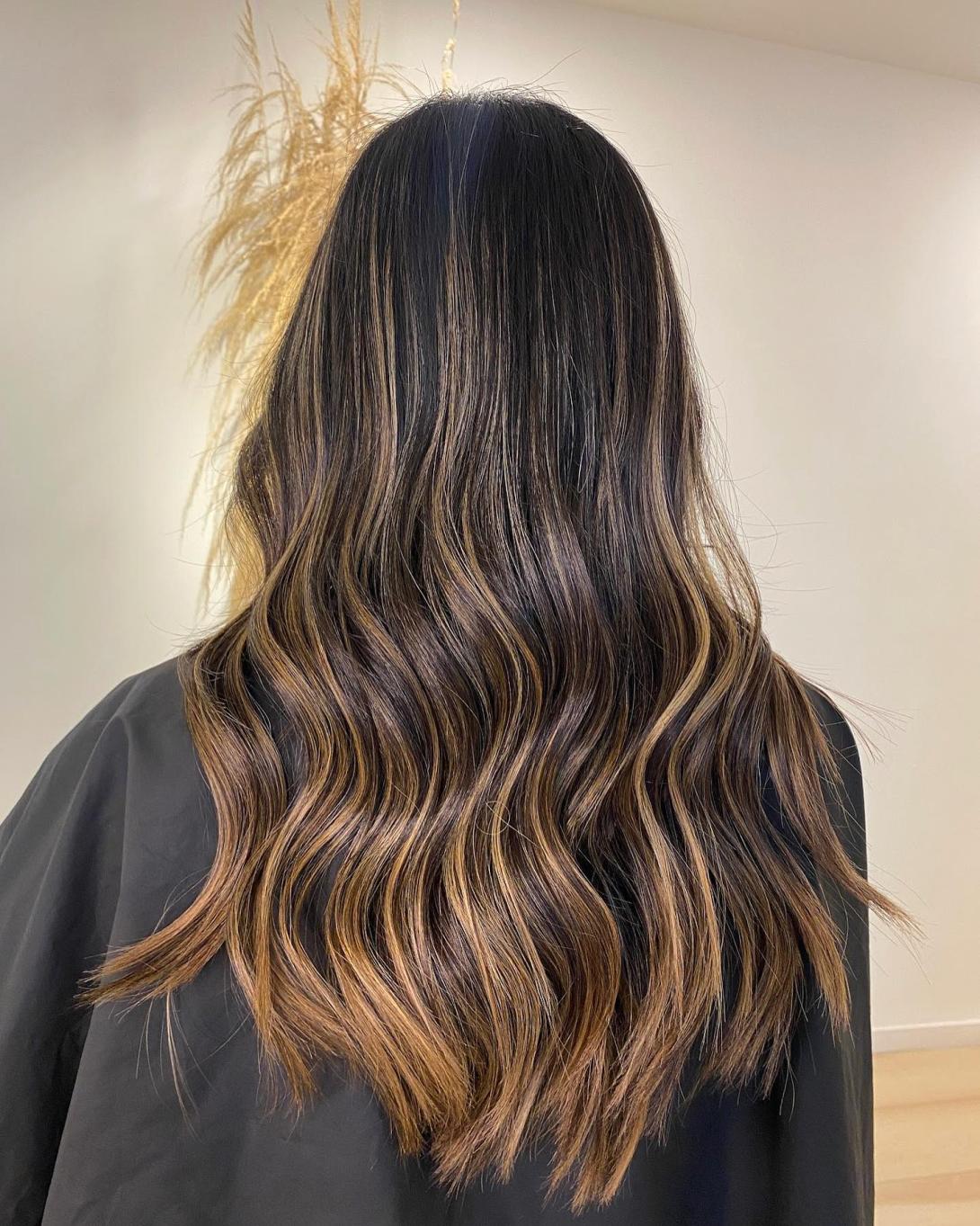 Professional hairstylist applying hair color to a client in a modern New York City salon, highlighting expert hair coloring and personalized salon care.